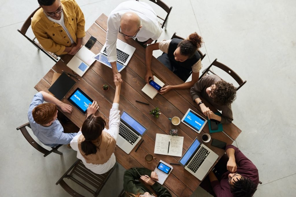 Meeting from above - shaking hands with laptops